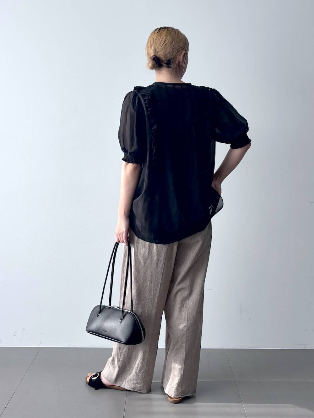 ベージュ系のその他パンツ、ブラック系のシャツ/ブラウス、ブラック系のハンドバッグを着用したレディースの春コーディネートの4枚目の写真