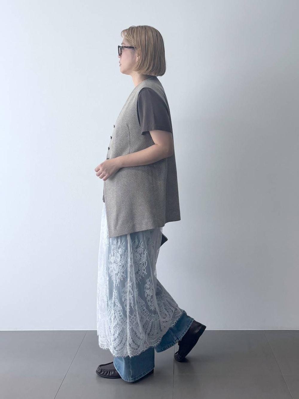 ブラウン系のハンドバッグ、ブラウン系のローファー、グレー系のTシャツ/カットソーを着用したレディースの夏コーディネートの3枚目の写真