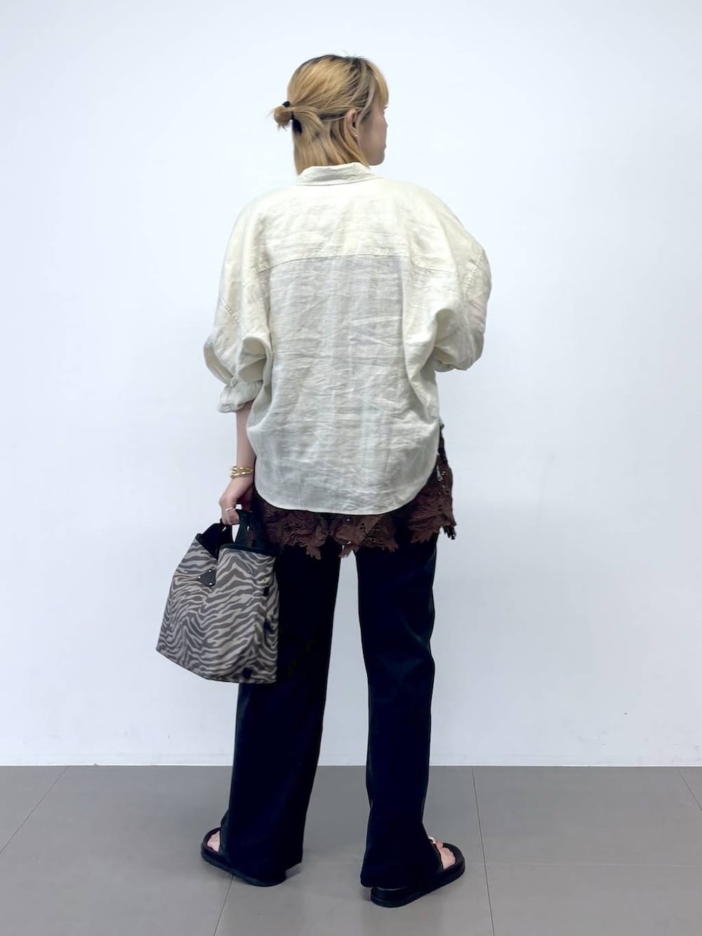 グレー系のトートバッグ、ブラック系のチノパンツ、ブラウン系のシャツ/ブラウスを着用したレディースの夏コーディネートの5枚目の写真
