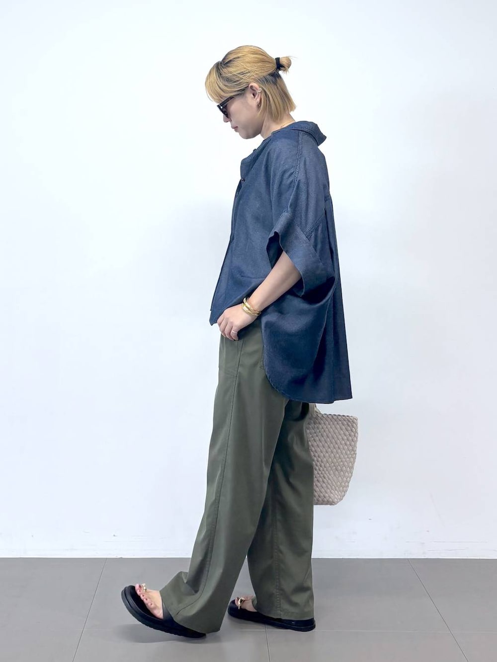 グリーン系のチノパンツ、ブルー系のTシャツ/カットソー、ブラック系のサンダルを着用したレディースの夏コーディネートの3枚目の写真