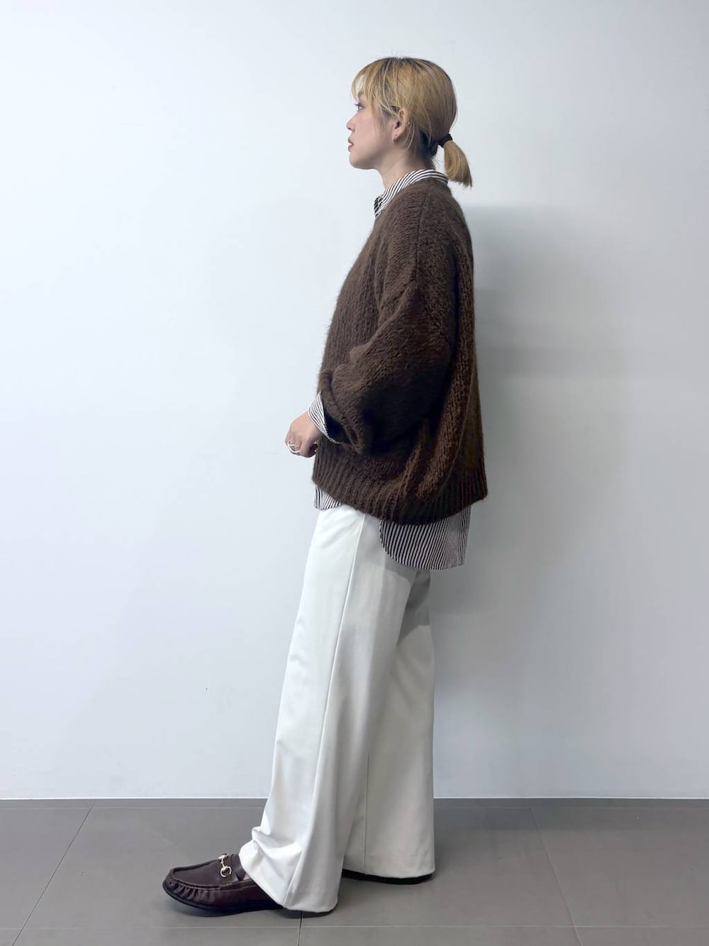 ブラウン系のローファー、ベージュ系のシャツ/ブラウス、ブラウン系のニット/セーターを着用したレディースの秋コーディネートの3枚目の写真