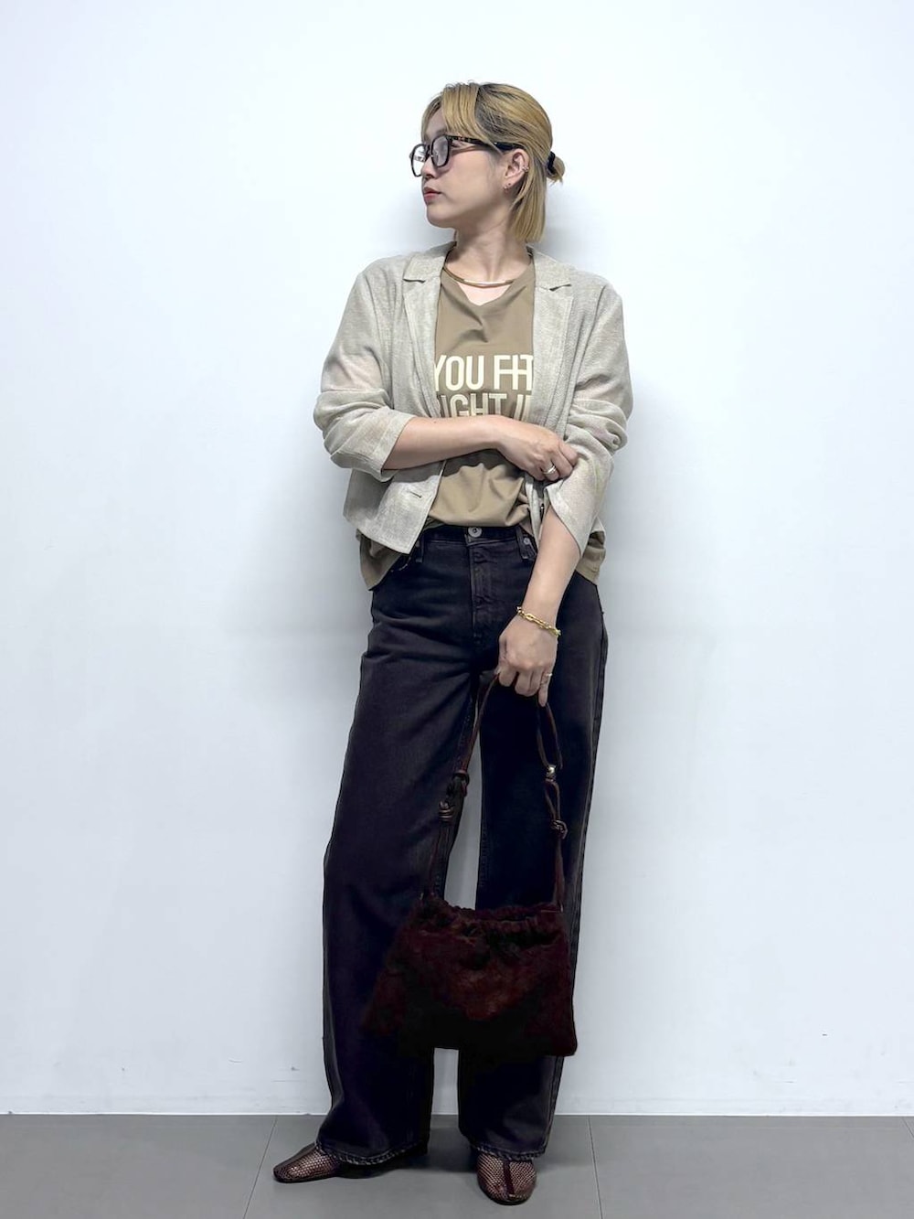 ベージュ系のテーラードジャケット、ベージュ系のTシャツ/カットソー、ブラウン系のデニムパンツを着用したレディースの夏コーディネートの2枚目の写真