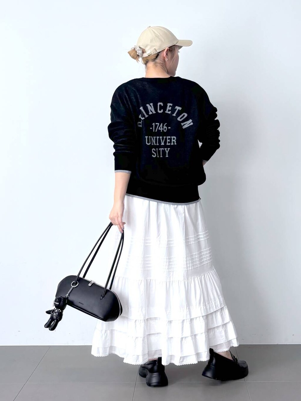 ホワイト系のTシャツ/カットソー、ホワイト系のスカート、ブラック系のハンドバッグを着用したレディースの春コーディネートの4枚目の写真