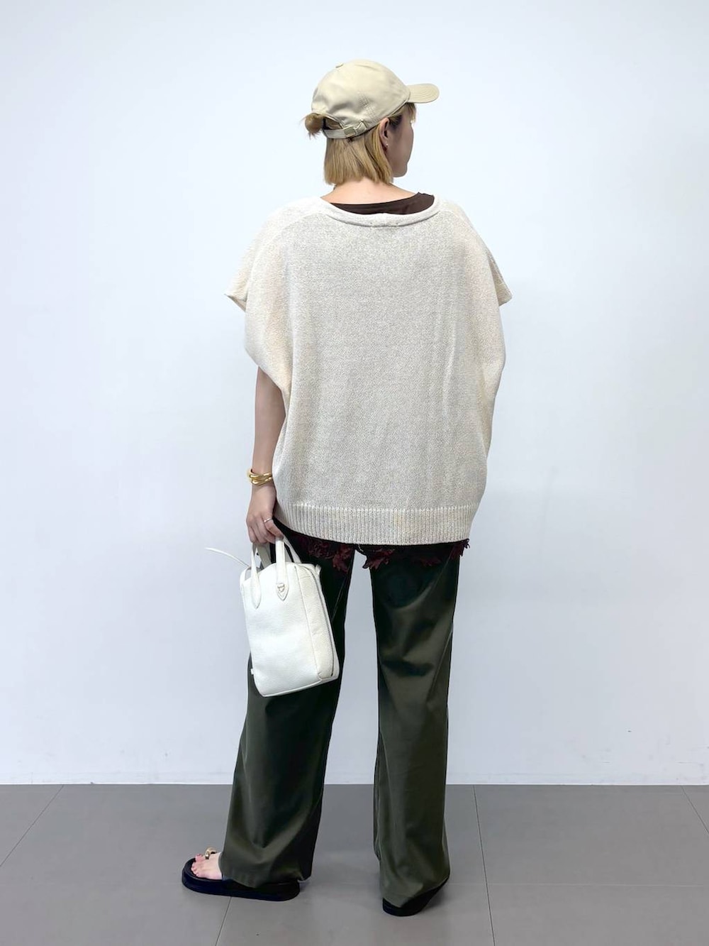 グリーン系のチノパンツ、ホワイト系のショルダーバッグ、ブラック系のサンダルを着用したレディースの夏コーディネートの5枚目の写真