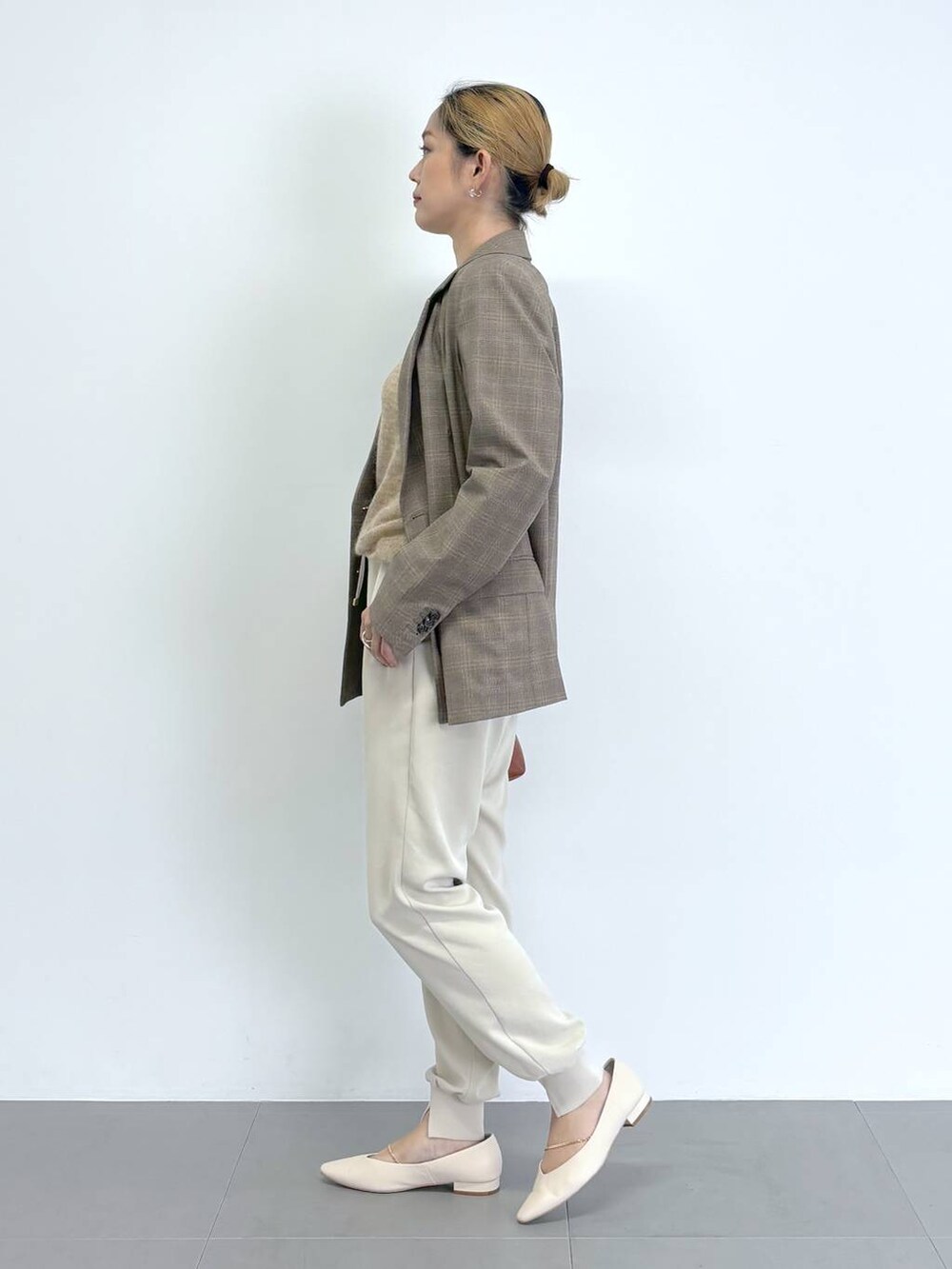 ブラウン系のショルダーバッグ、ホワイト系のその他パンツ、ベージュ系のニット/セーターを着用したレディースの秋コーディネートの3枚目の写真