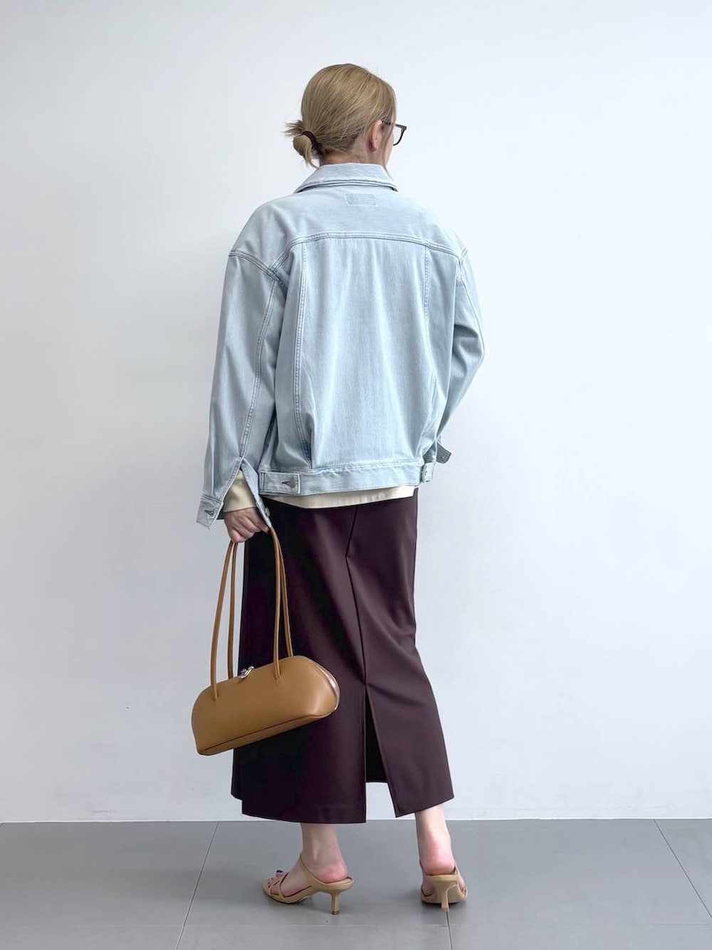 ブルー系のデニムジャケット、ブラウン系のスカート、ブラウン系のサングラスを着用したレディースの冬コーディネートの4枚目の写真