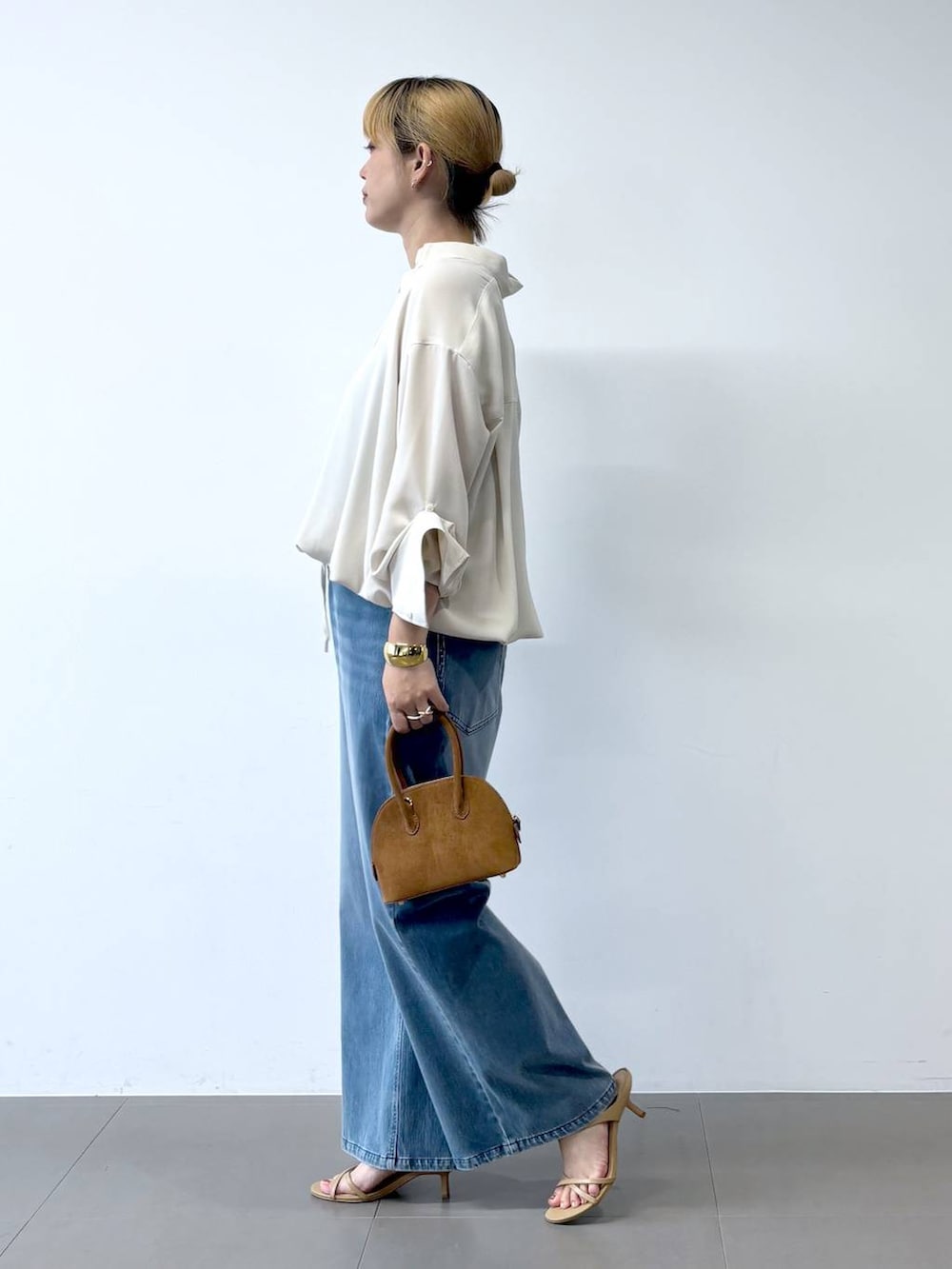 ブルー系のデニムパンツ、ベージュ系のサンダル、ホワイト系のシャツ/ブラウスを着用したレディースの夏コーディネートの4枚目の写真