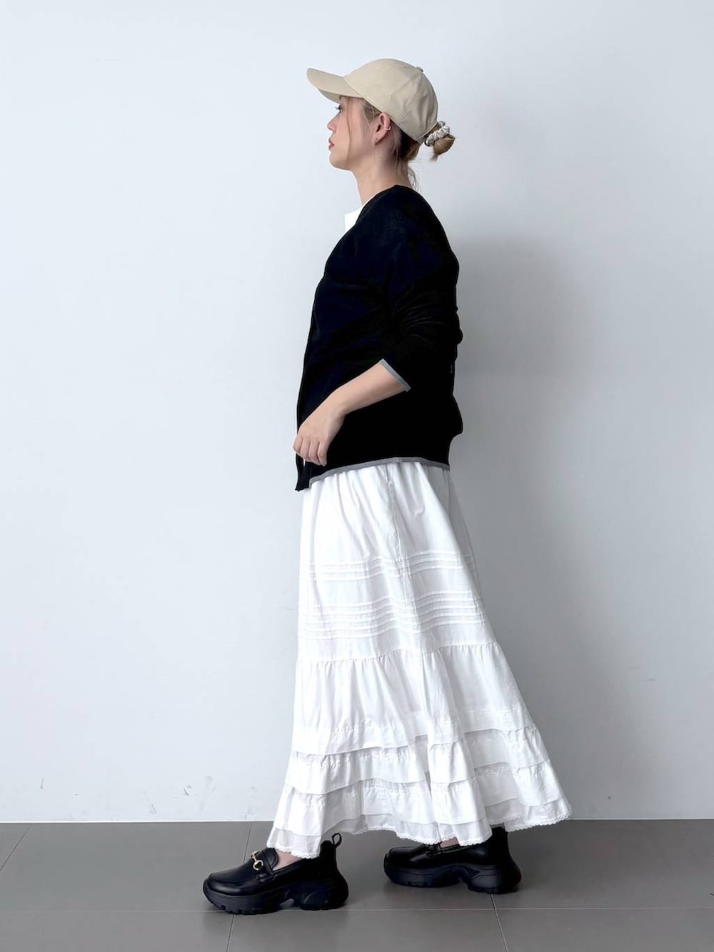 ホワイト系のTシャツ/カットソー、ホワイト系のスカート、ブラック系のハンドバッグを着用したレディースの春コーディネートの3枚目の写真