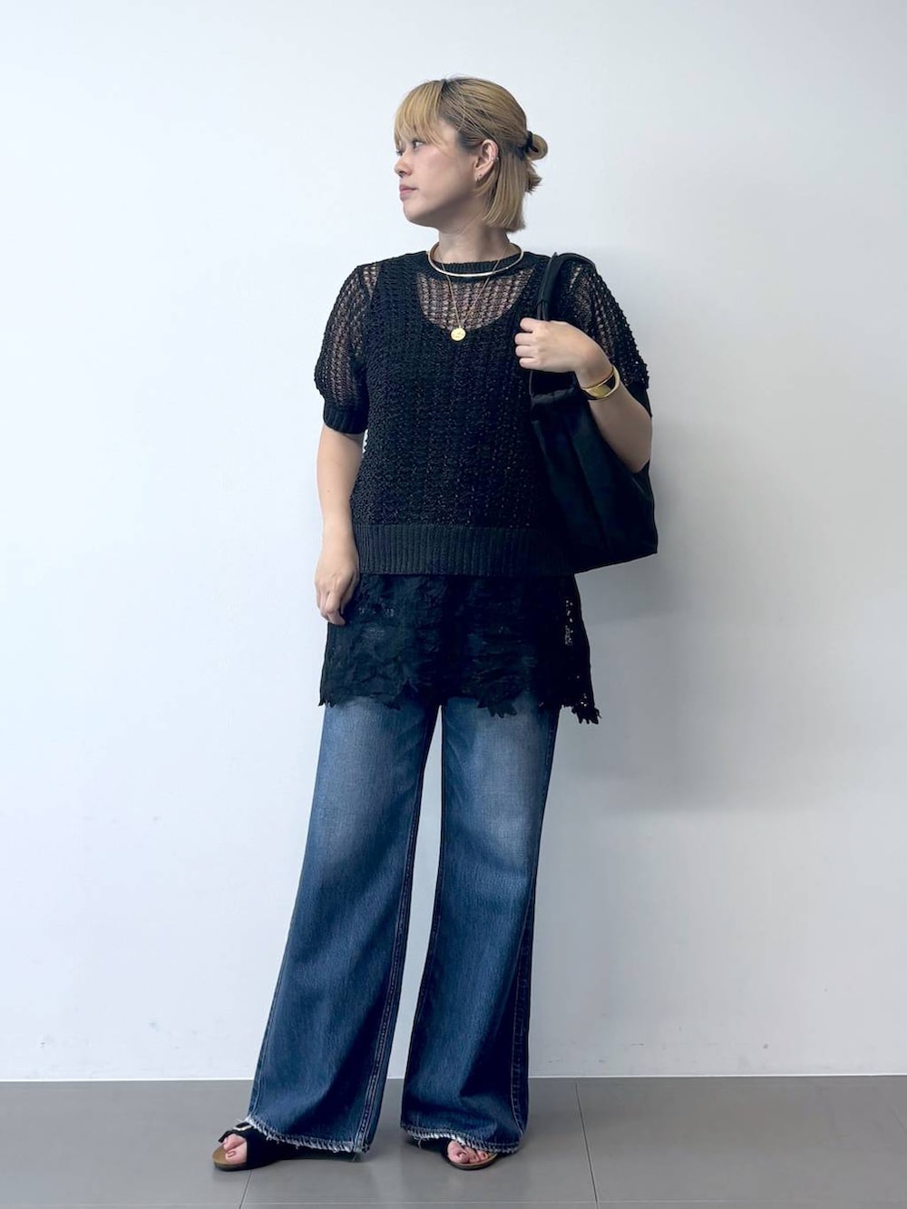 ブラック系のサンダル、ブラック系のタンクトップ、ブルー系のデニムパンツを着用したレディースの夏コーディネートの2枚目の写真