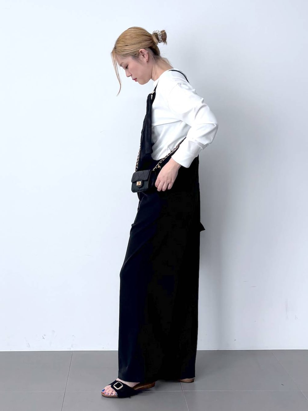 ブラック系のブルゾン、ホワイト系のTシャツ/カットソー、ブラック系のサロペット/オーバーオールを着用したレディースの春コーディネートの3枚目の写真