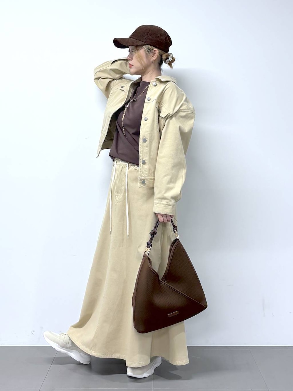 ブラウン系のTシャツ/カットソー、ベージュ系のスカート、ベージュ系のデニムジャケットを着用したレディースの冬コーディネートの2枚目の写真