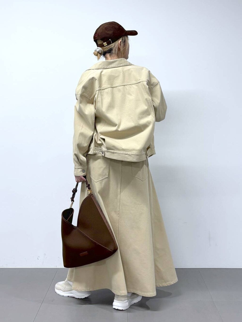 ブラウン系のTシャツ/カットソー、ベージュ系のスカート、ベージュ系のデニムジャケットを着用したレディースの冬コーディネートの5枚目の写真