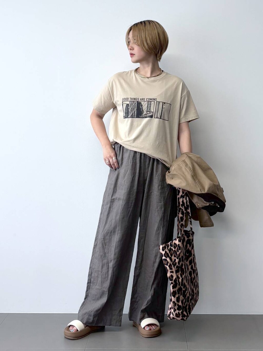 ベージュ系のミリタリージャケット、グリーン系のその他パンツ、その他のトートバッグを着用したレディースの春コーディネートの5枚目の写真