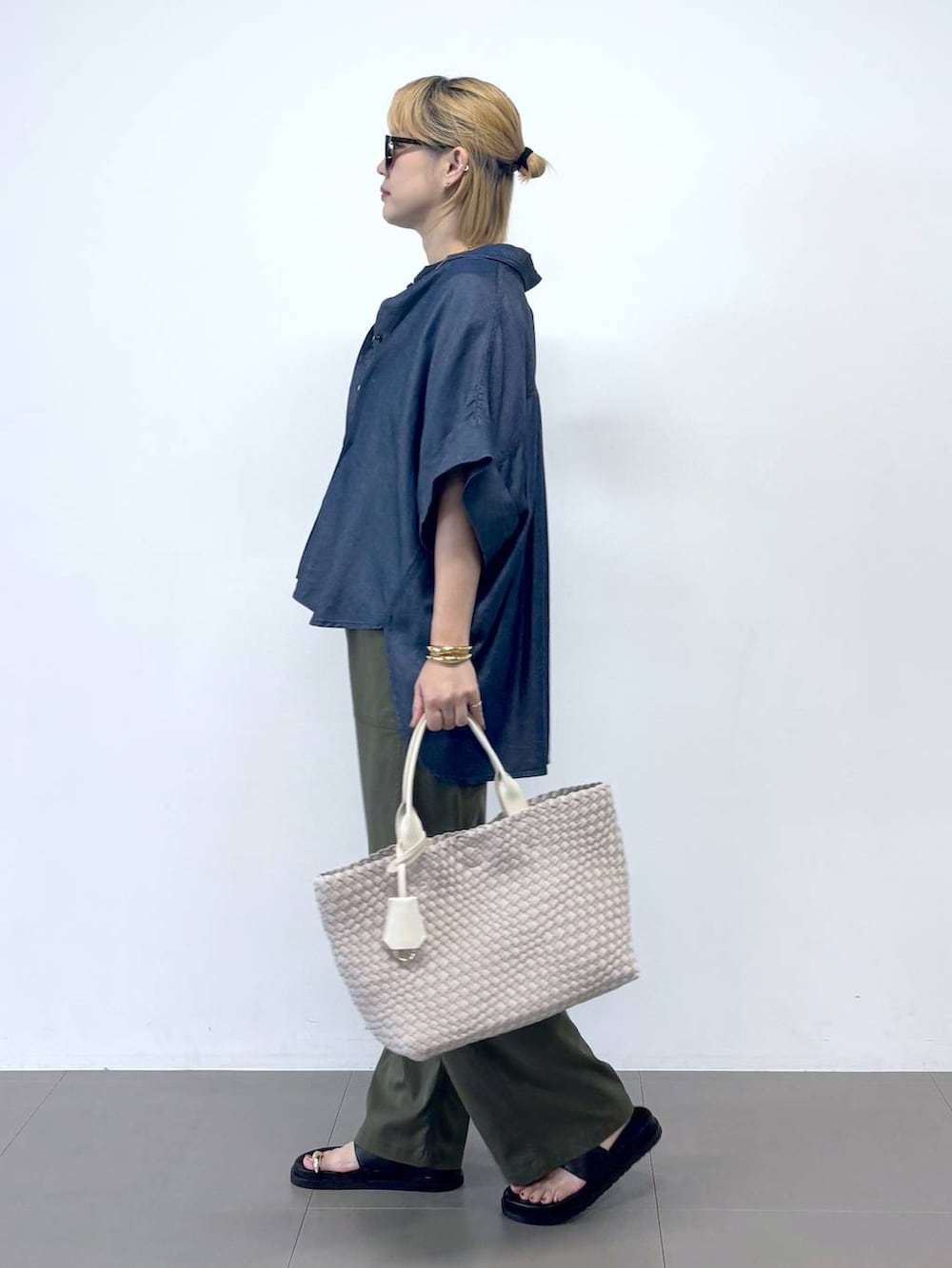 グリーン系のチノパンツ、ブルー系のTシャツ/カットソー、ブラック系のサンダルを着用したレディースの夏コーディネートの2枚目の写真