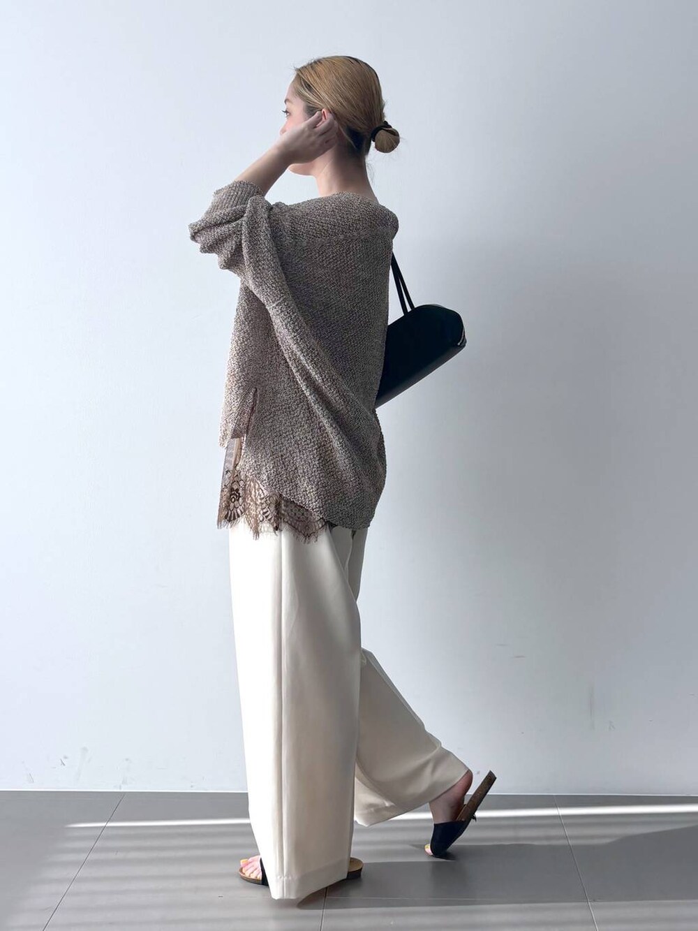 ブラウン系のカーディガン/ボレロ、ブラック系のハンドバッグ、ホワイト系のその他パンツを着用したレディースの春コーディネートの4枚目の写真