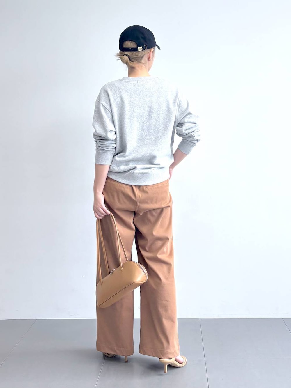 ベージュ系のニット/セーター、グレー系のスウェット、イエロー系のその他パンツを着用したレディースの冬コーディネートの7枚目の写真