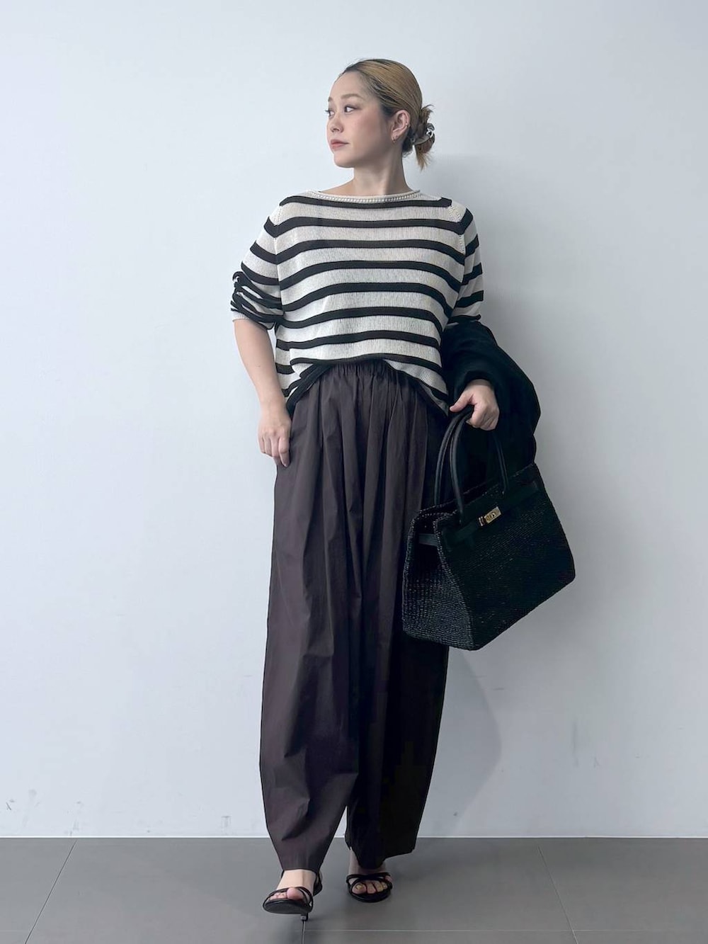 ブラウン系のその他パンツ、ベージュ系のニット/セーター、ブラック系のテーラードジャケットを着用したレディースの春コーディネートの2枚目の写真