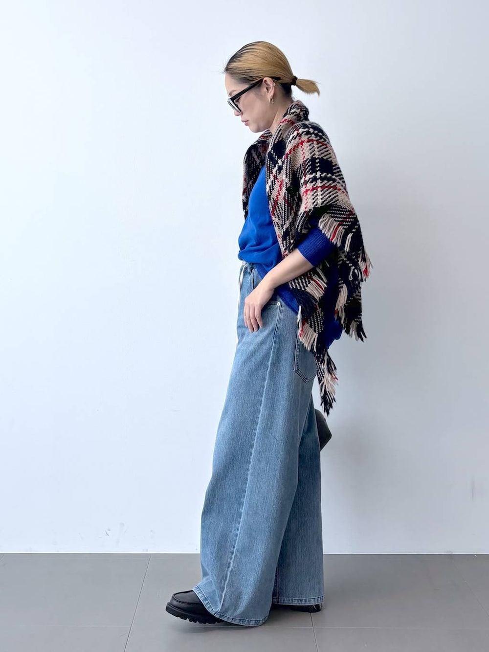 ブラック系のトートバッグ、ブルー系のデニムパンツ、ブラック系のローファーを着用したレディースの秋コーディネートの2枚目の写真