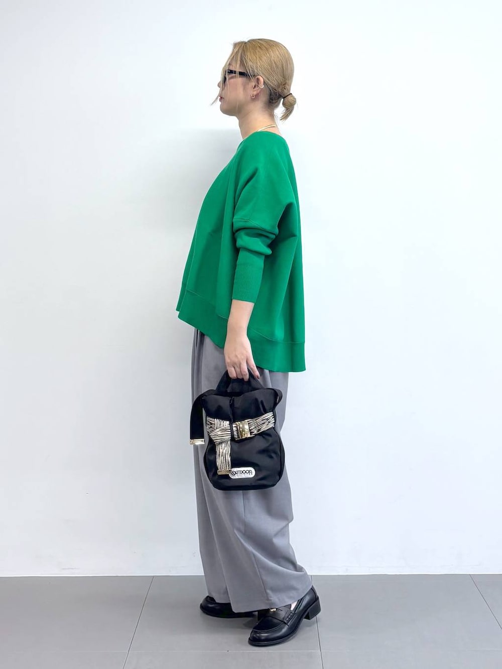 グリーン系のニット/セーター、グレー系のその他パンツ、その他のショルダーバッグを着用したレディースの冬コーディネートの2枚目の写真