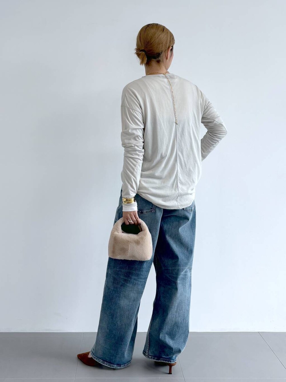 ブルー系のデニムパンツ、ホワイト系のショルダーバッグ、ホワイト系のTシャツ/カットソーを着用したレディースの夏コーディネートの4枚目の写真