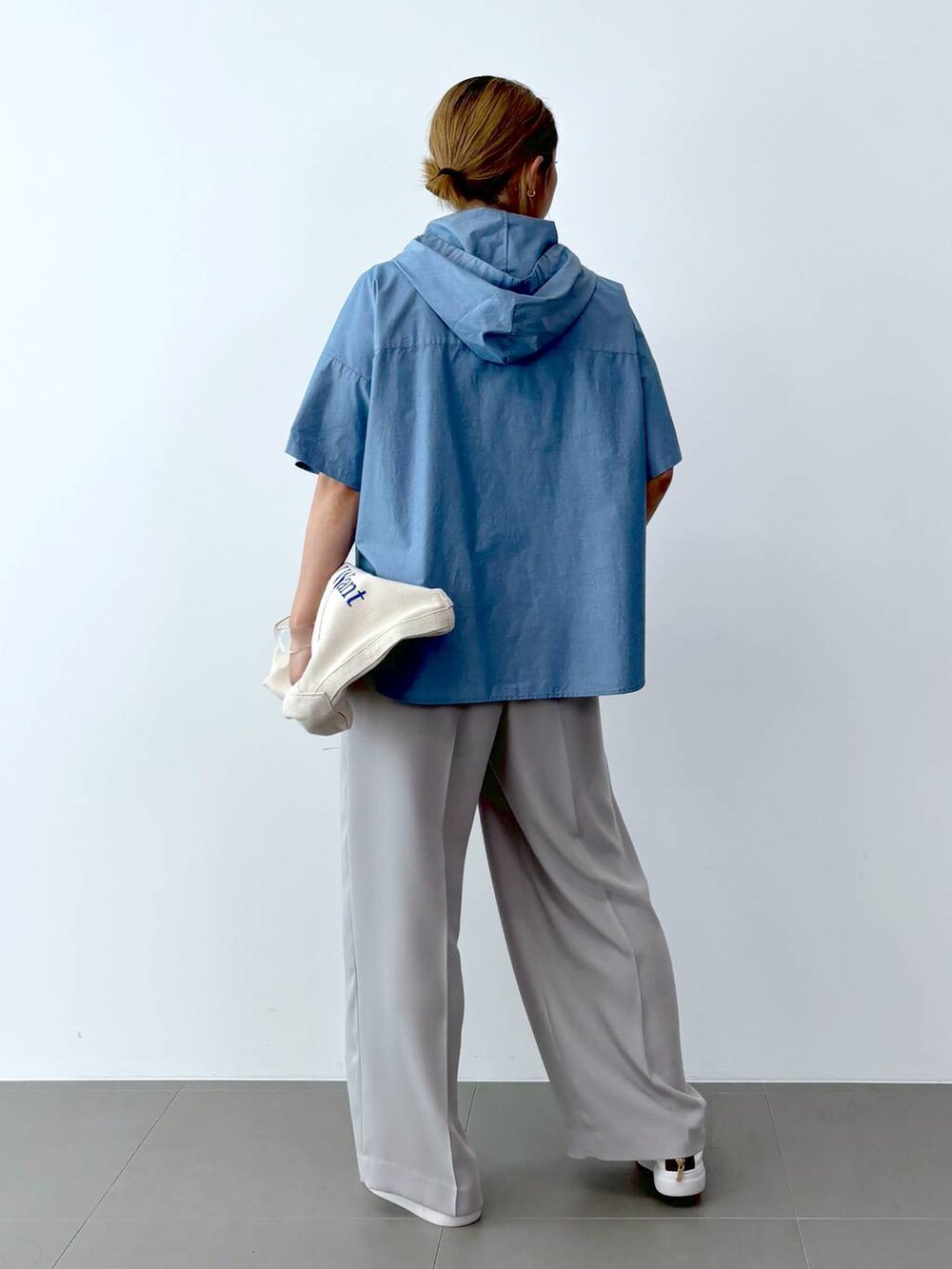 ブラック系のTシャツ/カットソー、ホワイト系のトートバッグ、ホワイト系のスニーカーを着用したレディースの夏コーディネートの4枚目の写真