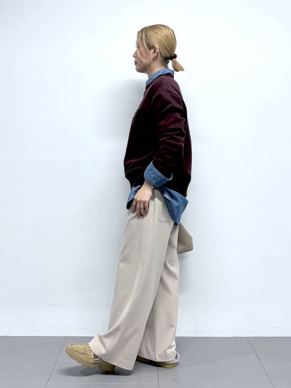 ベージュ系のローファー、レッド系のスウェット、ベージュ系のその他パンツを着用したレディースの秋コーディネートの3枚目の写真