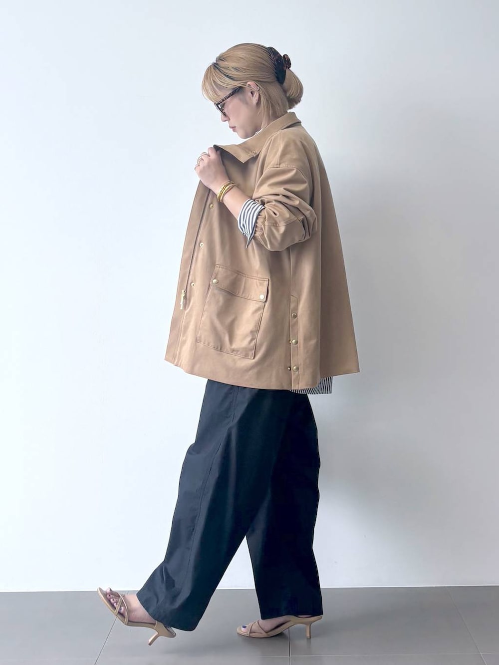 ブラウン系のボストンバッグ、ホワイト系のシャツ/ブラウス、ベージュ系のサンダルを着用したレディースの秋コーディネートの4枚目の写真
