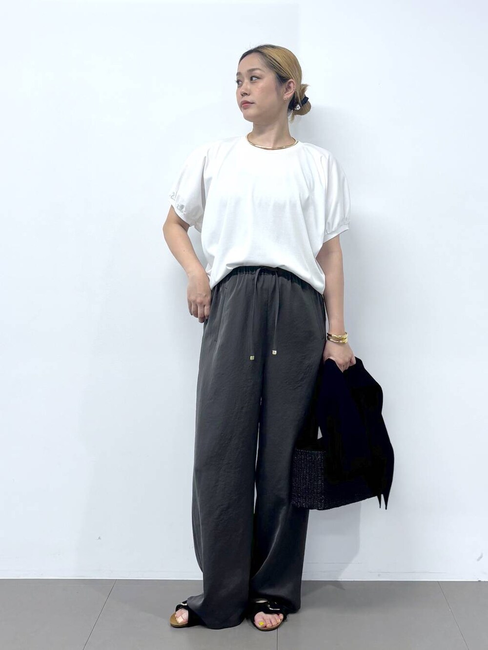 グレー系のその他パンツ、ホワイト系のTシャツ/カットソー、ブラック系のサンダルを着用したレディースの春コーディネートの5枚目の写真