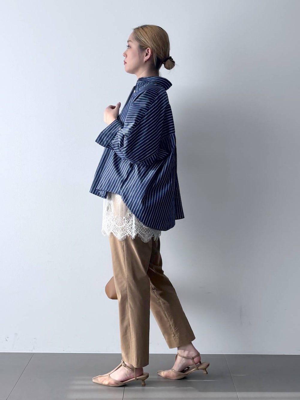 ブルー系のシャツ/ブラウス、ブラウン系のハンドバッグ、ベージュ系のその他パンツを着用したレディースの春コーディネートの4枚目の写真