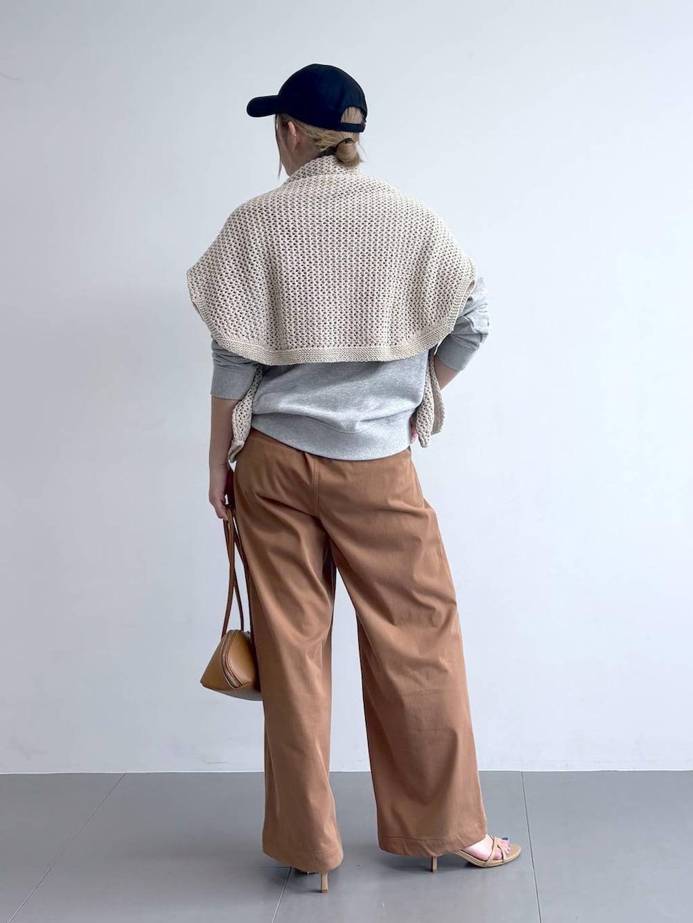 ベージュ系のニット/セーター、グレー系のスウェット、イエロー系のその他パンツを着用したレディースの冬コーディネートの4枚目の写真