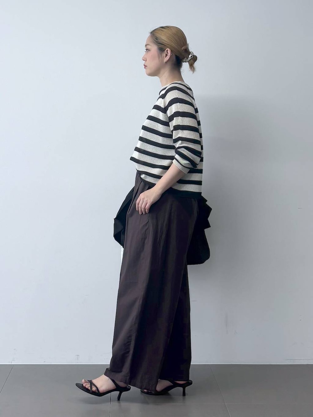 ブラウン系のその他パンツ、ベージュ系のニット/セーター、ブラック系のテーラードジャケットを着用したレディースの春コーディネートの3枚目の写真