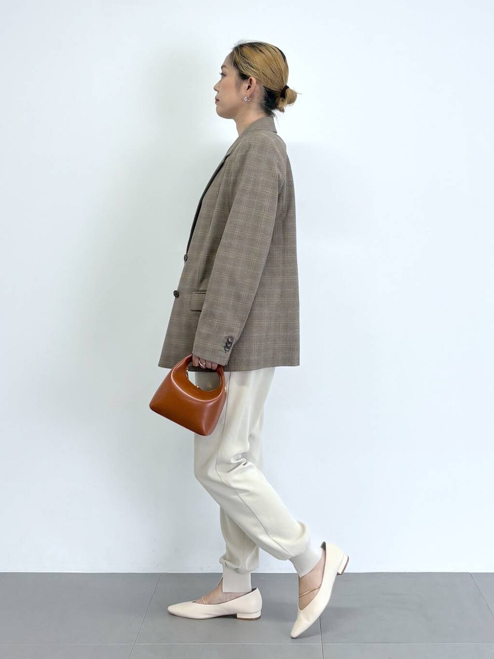 ブラウン系のショルダーバッグ、ホワイト系のその他パンツ、ベージュ系のニット/セーターを着用したレディースの秋コーディネートの2枚目の写真