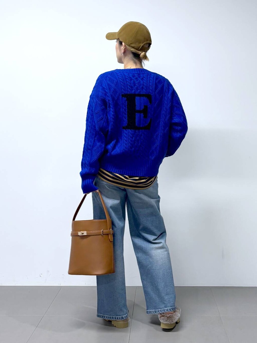 ブルー系のデニムパンツ、ベージュ系のTシャツ/カットソー、イエロー系のハンドバッグを着用したレディースの秋コーディネートの5枚目の写真