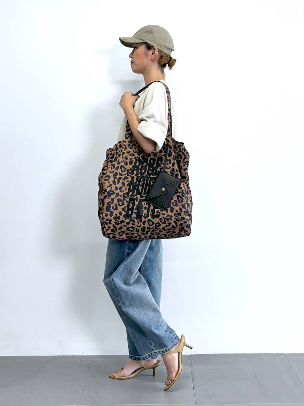 ベージュ系のスリッポン、ホワイト系のシャツ/ブラウス、ブルー系のデニムパンツを着用したレディースの夏コーディネートの3枚目の写真