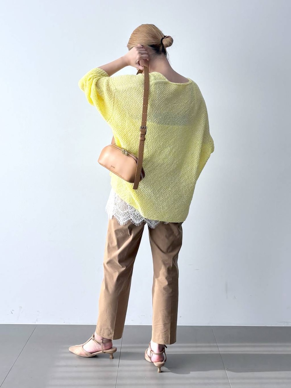 イエロー系のカーディガン/ボレロ、ベージュ系のその他パンツ、ブラウン系のショルダーバッグを着用したレディースの春コーディネートの4枚目の写真