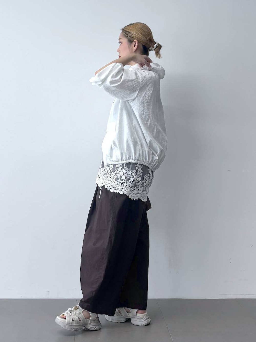 ブラウン系のその他パンツ、ベージュ系のショルダーバッグ、ホワイト系のブルゾンを着用したレディースの春コーディネートの3枚目の写真