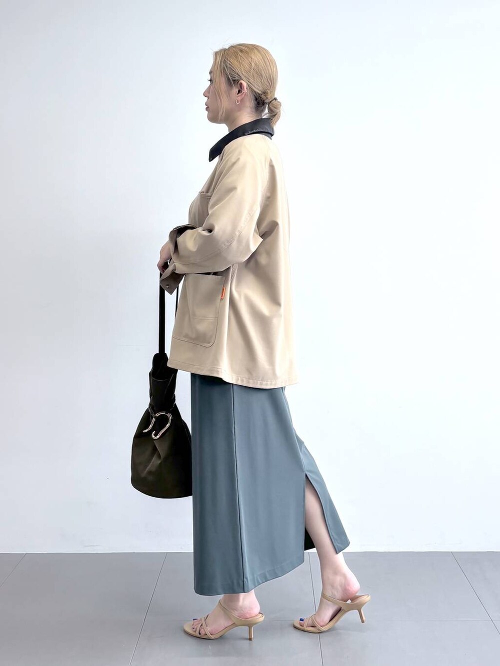 ホワイト系のTシャツ/カットソー、グリーン系のスカート、ベージュ系のカバーオールを着用したレディースの冬コーディネートの3枚目の写真