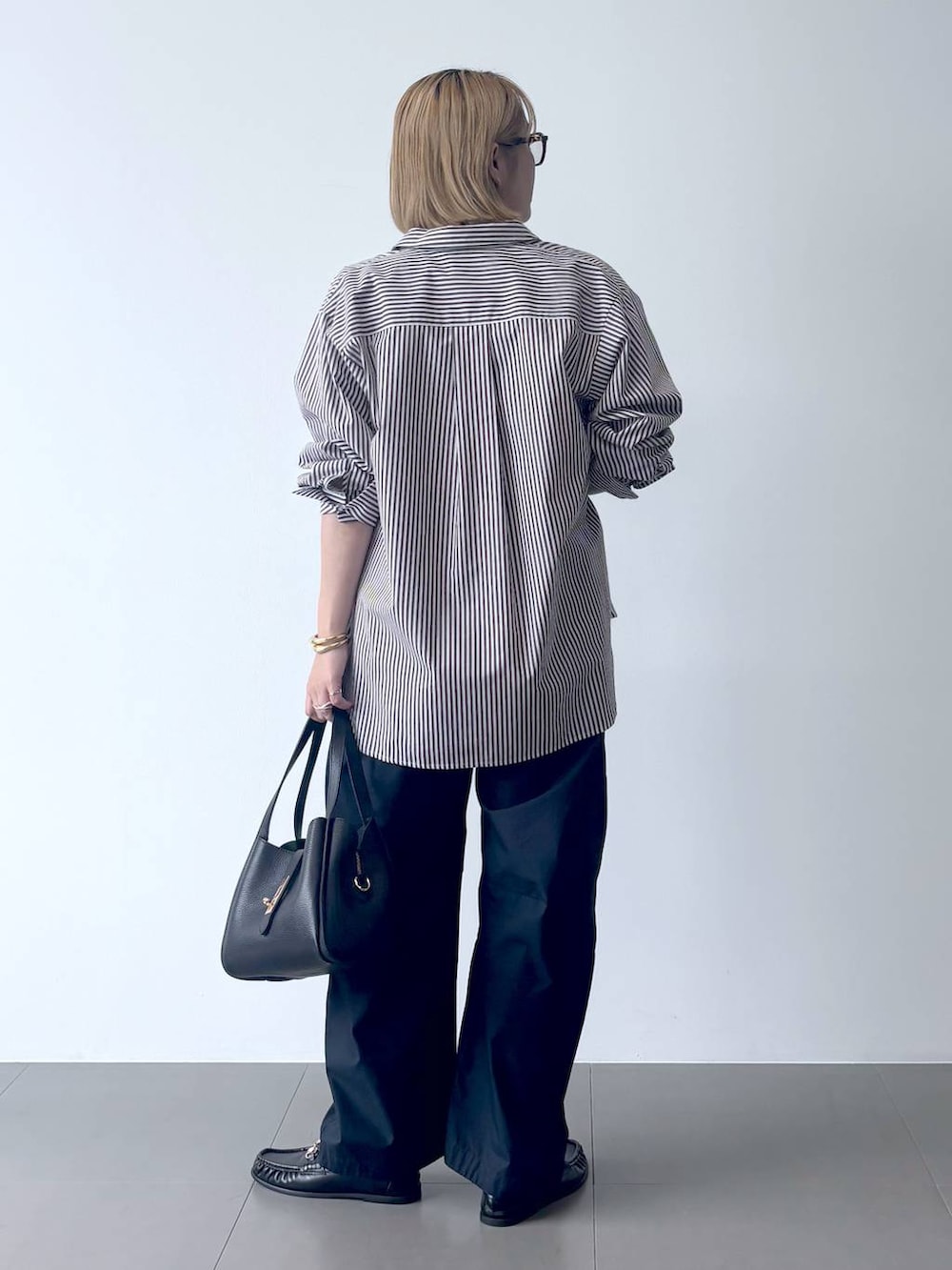 ブラック系のローファー、ブルー系のカーゴパンツ、ホワイト系のTシャツ/カットソーを着用したレディースの秋コーディネートの4枚目の写真