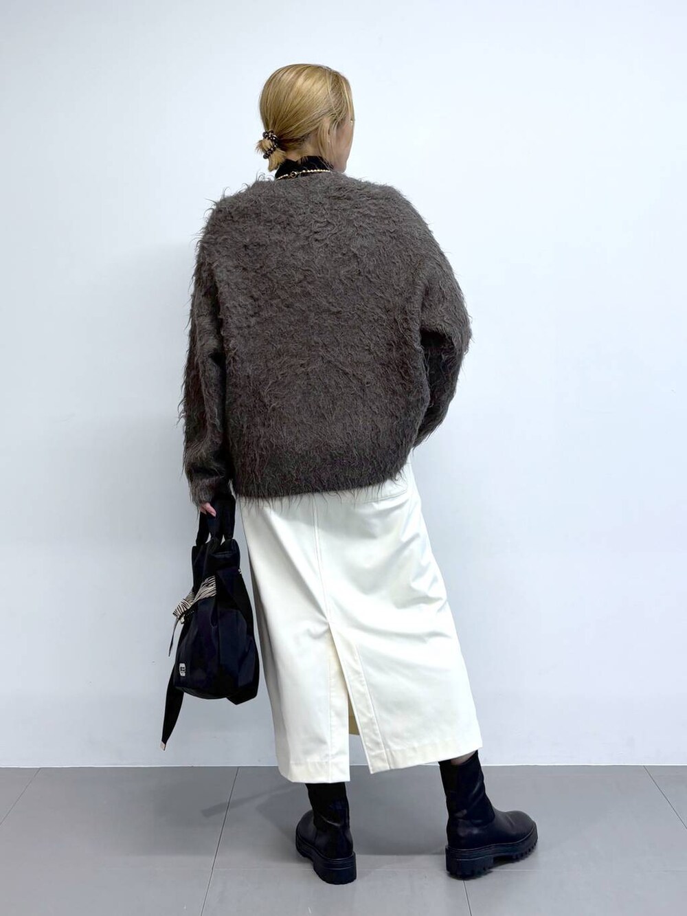 ブラック系のブーツ、ブラウン系のカーディガン/ボレロ、その他のショルダーバッグを着用したレディースの秋コーディネートの4枚目の写真