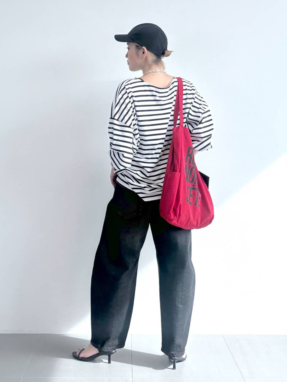 ブラック系のスリッポン、ホワイト系のTシャツ/カットソー、レッド系のトートバッグを着用したレディースの夏コーディネートの4枚目の写真