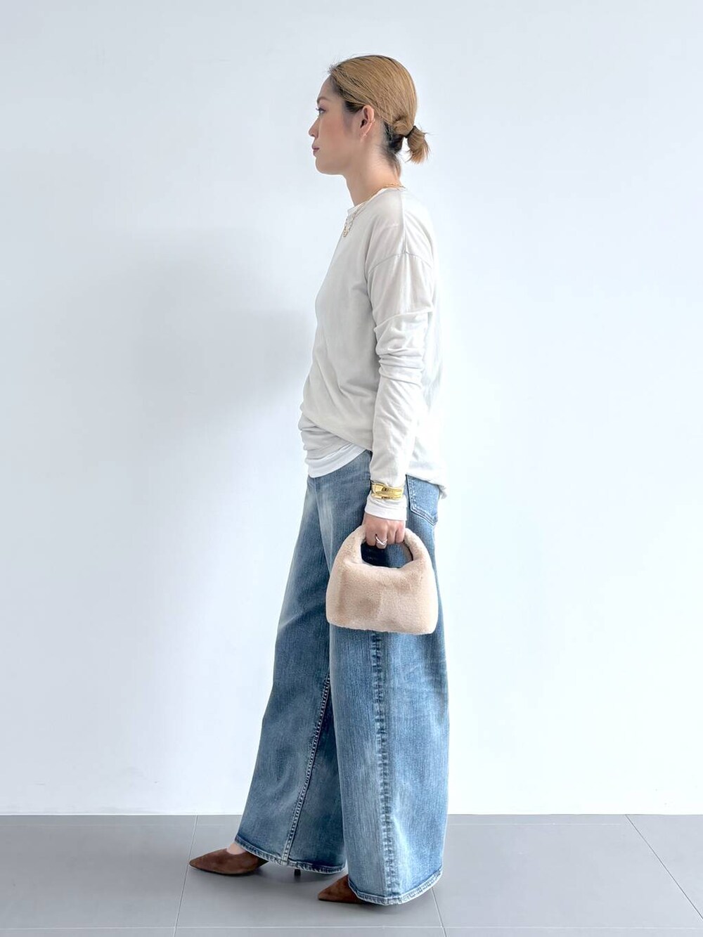 ブルー系のデニムパンツ、ホワイト系のショルダーバッグ、ホワイト系のTシャツ/カットソーを着用したレディースの夏コーディネートの2枚目の写真