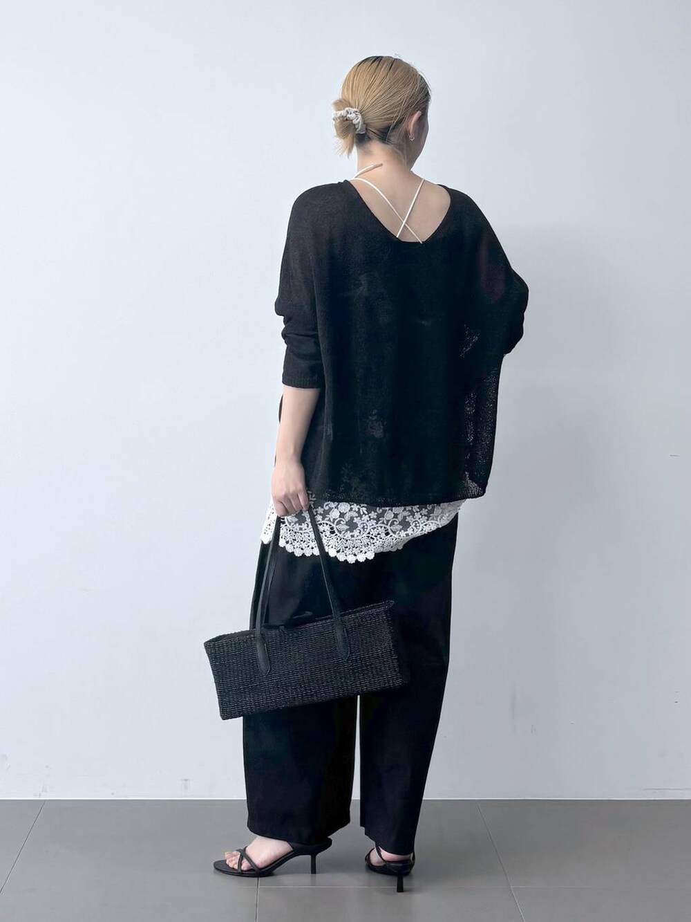 ブラック系のその他パンツ、ブラック系のかごバッグ、ブラック系のサンダルを着用したレディースの春コーディネートの4枚目の写真