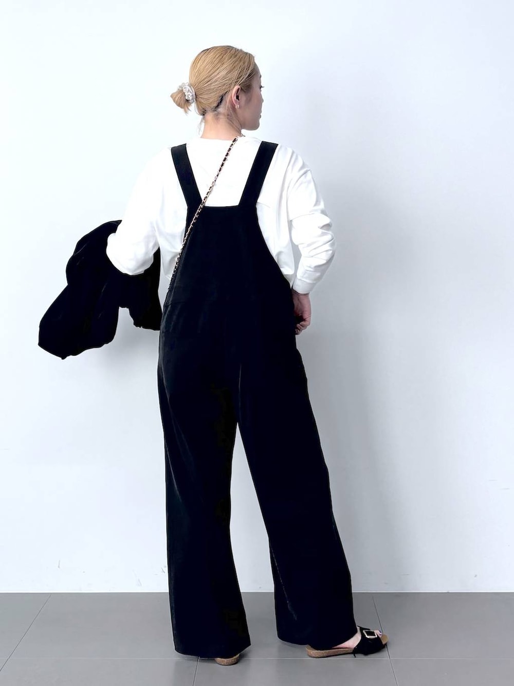 ブラック系のブルゾン、ホワイト系のTシャツ/カットソー、ブラック系のサロペット/オーバーオールを着用したレディースの春コーディネートの4枚目の写真