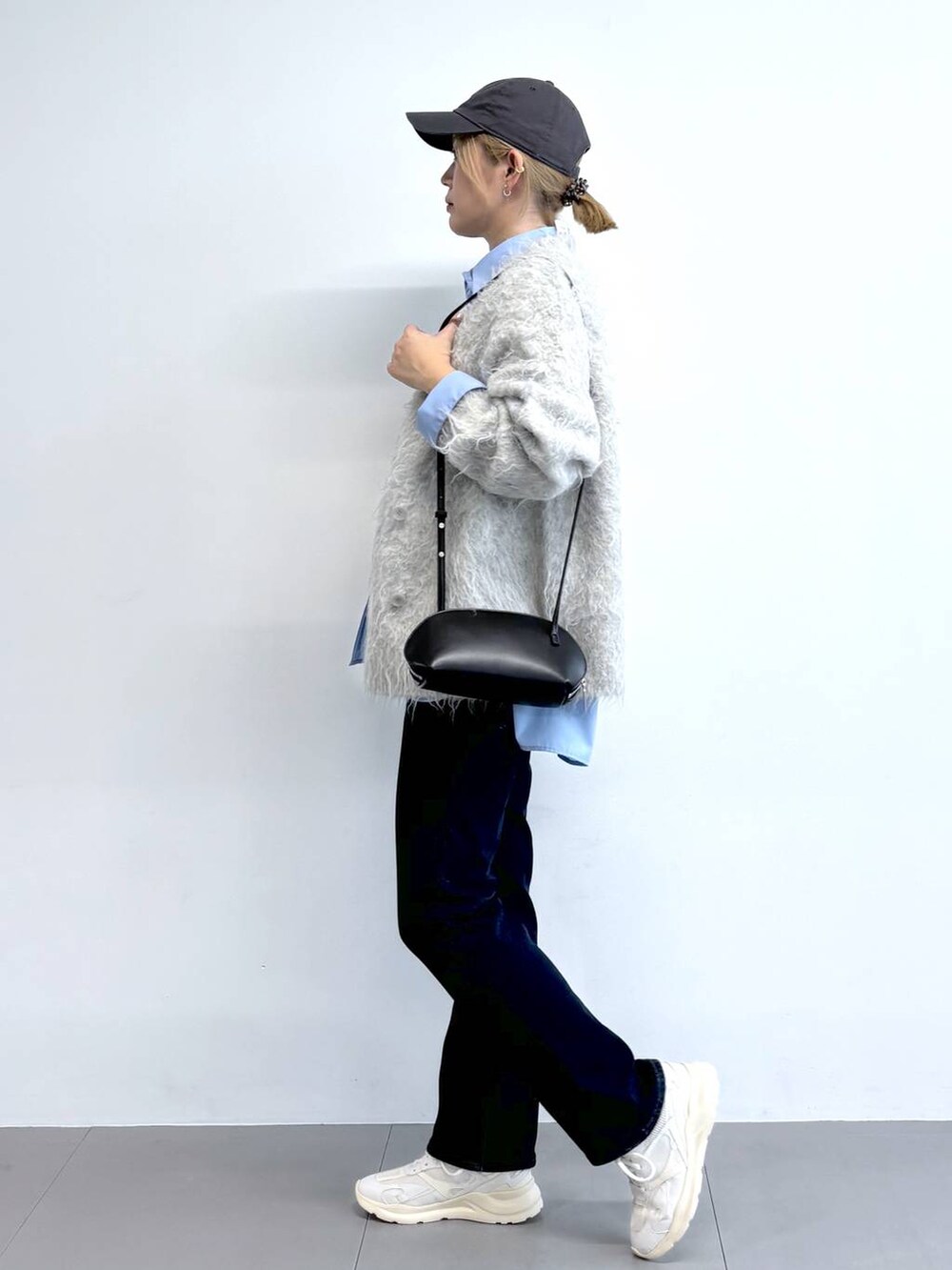 ブラック系のショルダーバッグ、ブルー系のシャツ/ブラウス、ブルー系のデニムパンツを着用したレディースの秋コーディネートの2枚目の写真