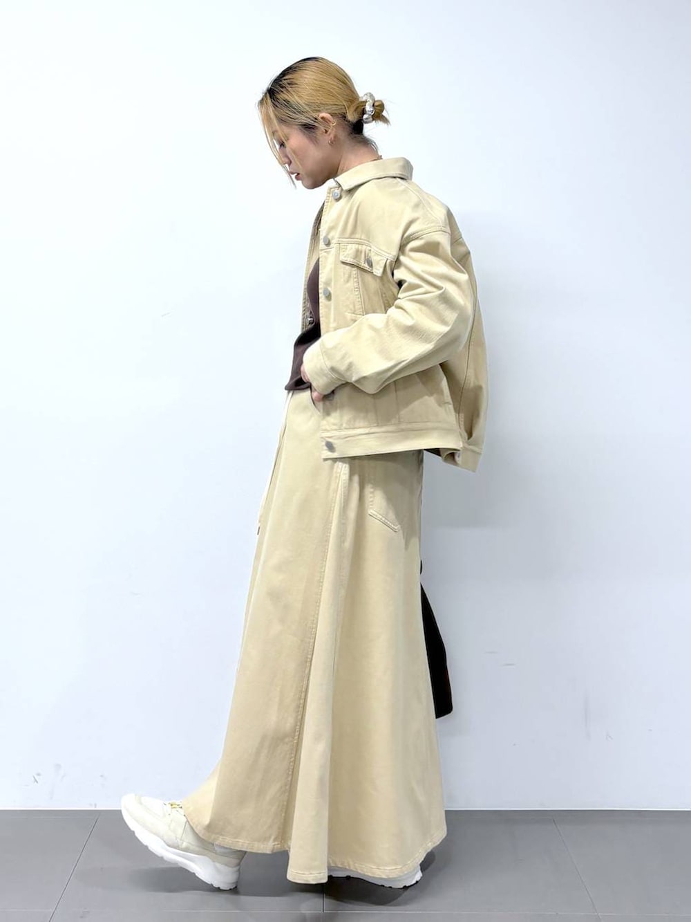 ブラウン系のTシャツ/カットソー、ベージュ系のスカート、ベージュ系のデニムジャケットを着用したレディースの冬コーディネートの3枚目の写真