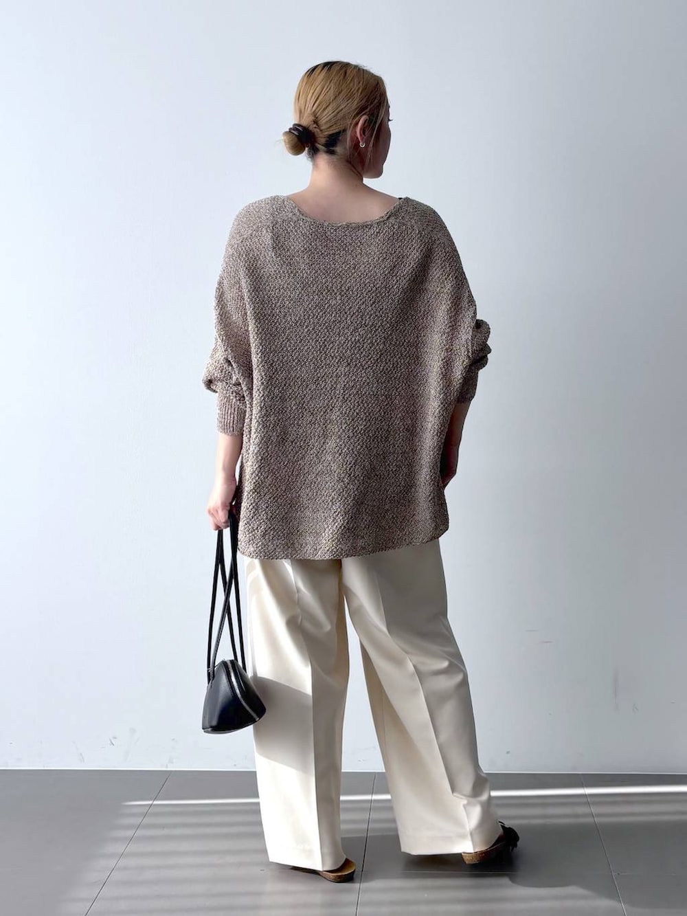 ブラウン系のカーディガン/ボレロ、ブラック系のハンドバッグ、ホワイト系のその他パンツを着用したレディースの春コーディネートの6枚目の写真