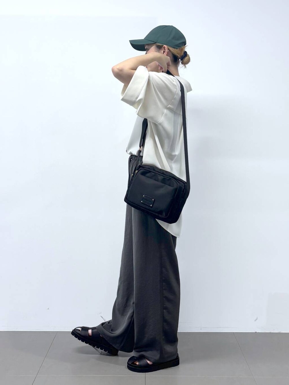 グレー系のその他パンツ、ホワイト系のシャツ/ブラウス、ブラック系のサンダルを着用したレディースの春コーディネートの2枚目の写真