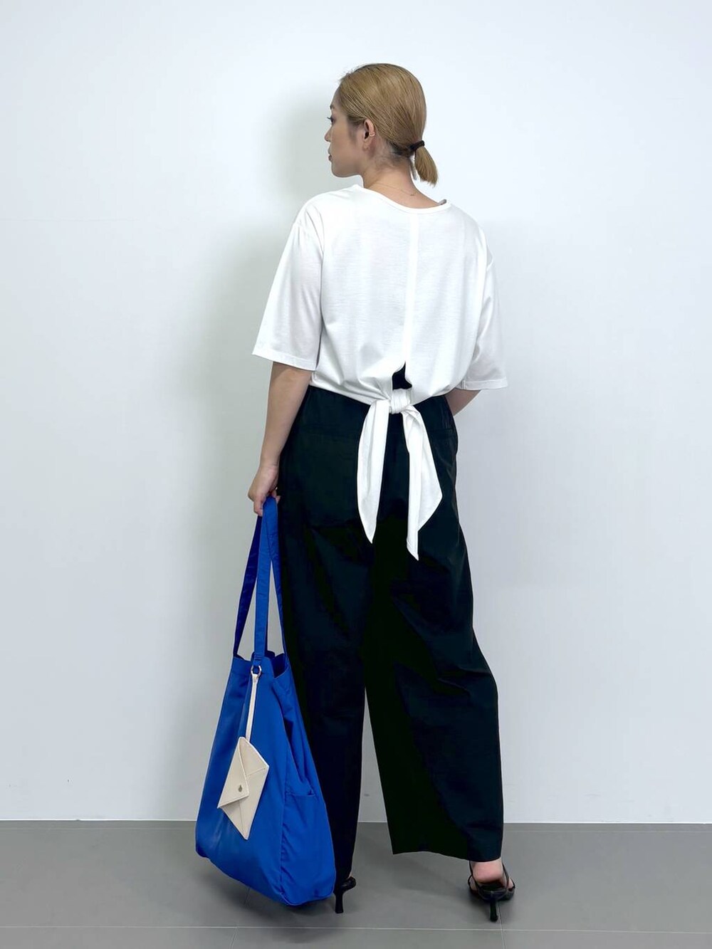 ブラック系のスリッポン、ブラック系のその他パンツ、ホワイト系のTシャツ/カットソーを着用したレディースの夏コーディネートの5枚目の写真