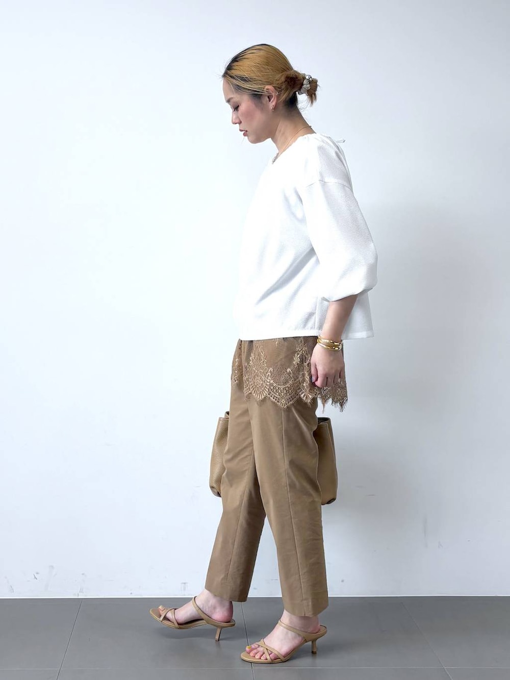 ホワイト系のシャツ/ブラウス、ベージュ系のその他パンツ、イエロー系のトートバッグを着用したレディースの春コーディネートの4枚目の写真