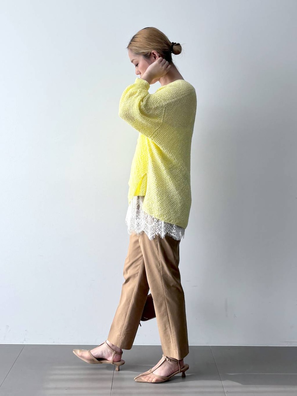 イエロー系のカーディガン/ボレロ、ベージュ系のその他パンツ、ブラウン系のショルダーバッグを着用したレディースの春コーディネートの3枚目の写真